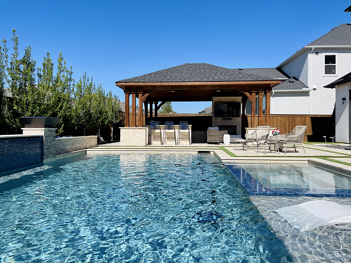 Clean backyard pool with a covered patio and outdoor kitchen in North Texas