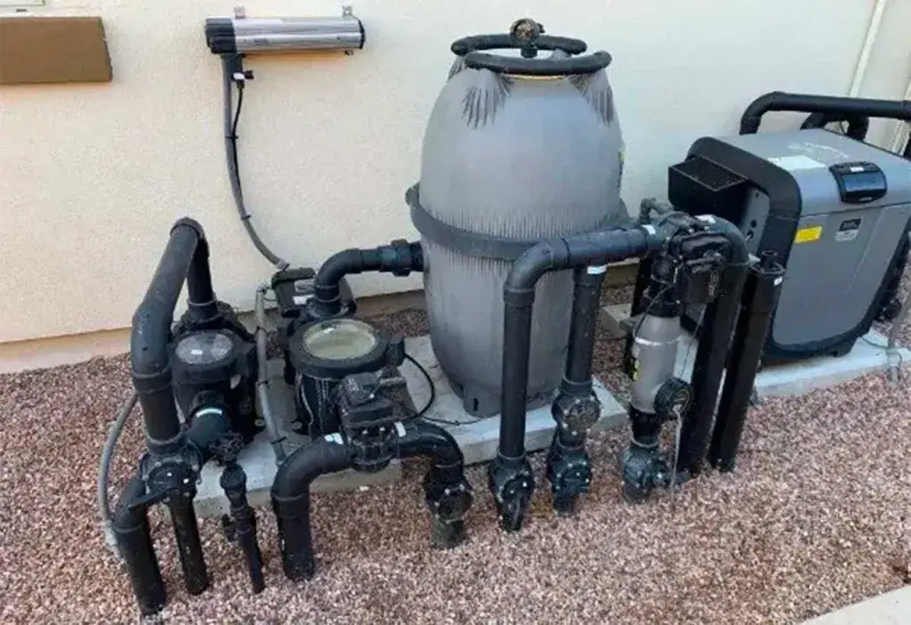 How long do pool pumps last: pool pump, sand filter and heat pump on an equipment pad